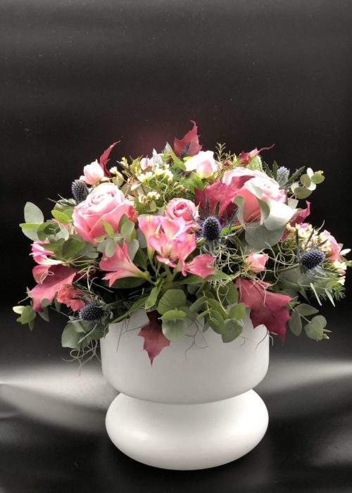 Σύνθεση λουλουδιών σε ροζ αποχρώσεις σε λευκή γυάλα 65€