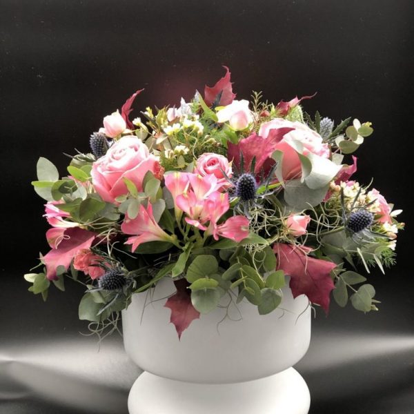Σύνθεση λουλουδιών σε ροζ αποχρώσεις σε λευκή γυάλα
